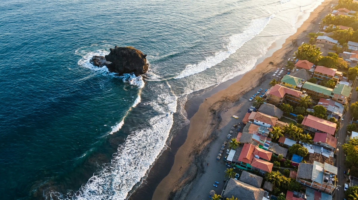 Playa El Tunco desde el aire — su roca icónica y el pueblo de surf más conocido de El Salvador.